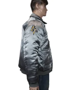 Battletech Mechwarrior embroidered bomber jacket, silver satin, left side view with a yellow shoulder logo on a mannequin.