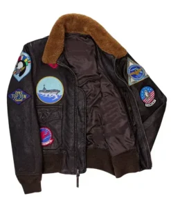 Front view of a maverick top gun jacket showing detailed flight patches, a premium brown leather finish, and a soft detachable shearling collar.