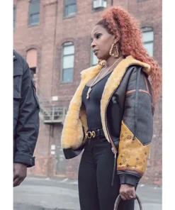 Mary J. Blige as Monet Tejada wearing the iconic Shearling Leather Jacket in Power Book II Ghost. This piece of Mary J. Blige's stylish outerwear features a prominent yellow shearling lining and monogram sleeve.