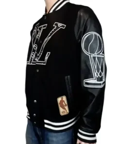 Side profile of the LV NBA Jacket for Men in black, highlighting the white outline of the NBA Championship trophy on the sleeve and a classic NBA logo patch near the pocket. This Louis Vuitton Basketball Jacket features contrasting white stripes on the collar and cuffs.