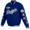 Los Angeles Dodgers World Series Champions Jacket in royal blue, featuring the "Dodgers" script logo on the chest and 2020 World Series Champions patch. The left sleeve is adorned with multiple patches, making it a distinct Dodgers World Series apparel piece.