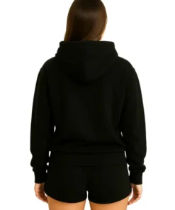 Back view of the woman wearing the plain black oversized hoodie and matching black shorts.