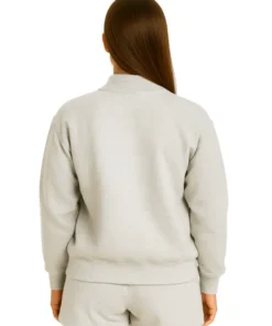 Back view of a woman wearing a plain, solid light grey oversized full-zip bomber jacket and matching shorts.