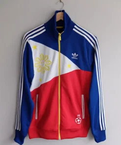 An Adidas jacket Philippines edition hanging on a wall, featuring the Filipino flag sun and stars embroidery and a white soccer ball PH logo.