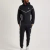 Front view of black Nike Tech reflective fleece tracksuit with white detailing and zip-up hoodie for men.