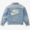 Blue denim jacket with large white Nike logo on the back.