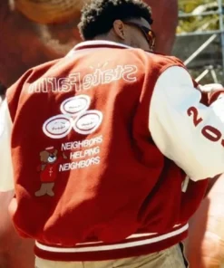 Back view of Travis Scott x State Farm varsity jacket with “Neighbors Helping Neighbors” text, bear graphic, and State Farm logo.