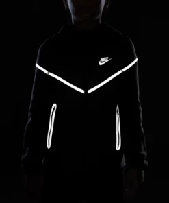 Black Nike Tech reflective jacket glowing in low light, showcasing reflective Nike Tech fleece design for men.