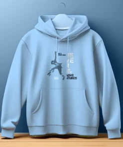 Never Say No Classic Hoodie in light blue with a bold graphic print of a person jumping and the text ‘Never Say No to Adventures’, featuring a kangaroo pocket.