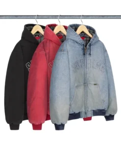 Three Supreme Reflective Arc Hooded Work Jackets hanging on wooden hangers in black, red, and light blue denim colors with embroidered Supreme logo across the chest