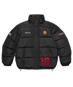 Full-frame front view of the black Supreme Umbro Down Puffer Jacket with a mock neck. It features 'Supreme' on the chest, a round patch emblem, an Umbro logo on the sleeve, and a large red '10' graphic.