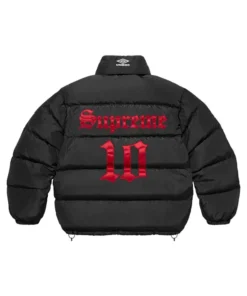 Full-frame back view of the black Supreme Umbro Down Puffer Jacket with a mock neck. It has a large red 'Supreme' and '10' graphic printed on the back.