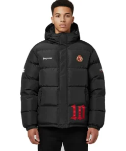 Front view of a model wearing the black Supreme Umbro Down Puffer Jacket with a hood. It features 'Supreme' on the chest, a round patch emblem, and a large red '10' graphic near the hem.