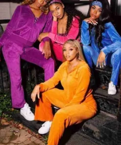 Four women wearing colorful cheetah girl tracksuit sets in purple, pink, blue, and orange, styled with headbands and white sneakers.