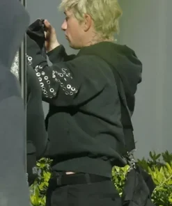 Barry Keoghan wearing the Crime 101 black pullover hoodie with silver eyelet sleeve design from the movie set.