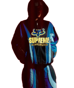 Model in blue and black Supreme Fox Racing Zip Up Hooded Sweatshirt with Pant featuring yellow Supreme Factory Team logo and bold street style design.