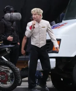 Barry Keoghan wearing the Crime 101 bellboy costume with beige jacket and dark pants from the movie set.