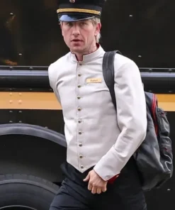 Crime 101 Barry Keoghan concierge outfit showing his stylish cream-colored jacket paired with black trousers.