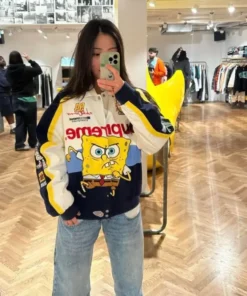 Full-body mirror selfie of a person wearing the white and navy Supreme SpongeBob SquarePants Cotton Racing Jacket with blue jeans, highlighting the vibrant spongebob racing jacket design.
