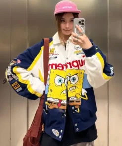 Stylish shot of a person wearing the Supreme x SpongeBob SquarePants Jacket in the navy, white, and yellow colorway, featuring a split, angry Spongebob graphic and a pink Supreme hat.