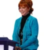 Reba McEntire in the coach chair wearing the The Voice S28 blue fringe coat and a black turtleneck.