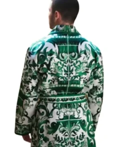 Nick Jonas facing away, wearing the distinctive green robe from the A Very Jonas Christmas movie. The robe features an ornate, green and white baroque pattern. Nick Jonas Robe A Very Jonas Christmas.