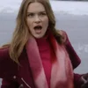 Close-up of Holland Roden looking surprised or excited, with her mouth open. She is outdoors in a winter setting, wearing a dark red or burgundy coat, a bright pink turtleneck, a fuzzy pink and red scarf, and dark gloves.