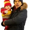 Rowan Atkinson Man VS Baby S01 Jacket. Trevor Bingley wears a blue parka jacket from the series, holding the baby in an outfit.