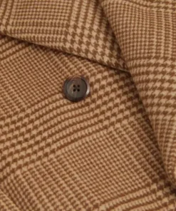 Close-up of the fabric and button detail on the Ryan Eggold Christmas movie wool coat. Brown and tan plaid pattern on the wool trench coat.
