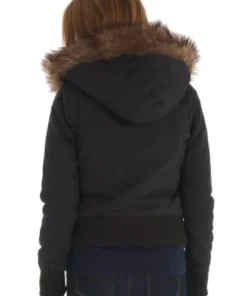 A rear view of a woman wearing the black Superdry Study Duffle Jacket. The image highlights the short, bomber-style length, the ribbed black waistband, and the wide Vegan fur trim around the hood.