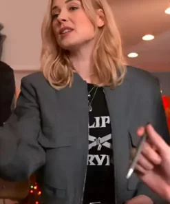 Blonde woman wearing a charcoal gray zip-up bomber jacket with a stand collar and front flap pockets indoors.