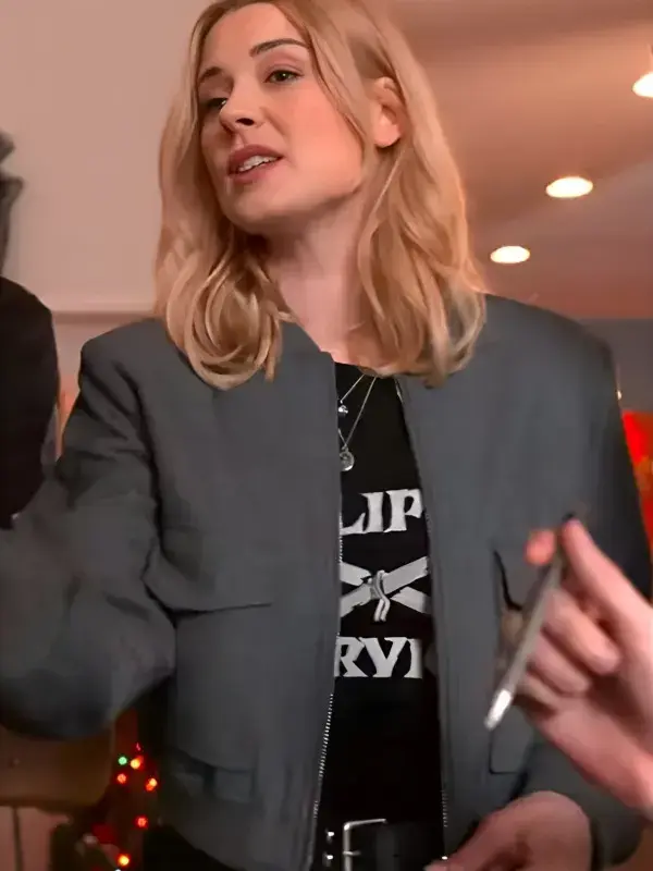Blonde woman wearing a charcoal gray zip-up bomber jacket with a stand collar and front flap pockets indoors.