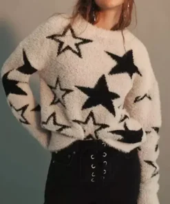 Woman wearing a white fuzzy star sweater with black star pattern and a relaxed fit.