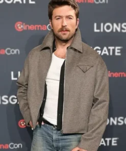 Actor Brandon Sklenar Andrew Winchester grey jacket in a medium close-up. The Housemaid Brandon Sklenar gray jacket shows a high-collar design.