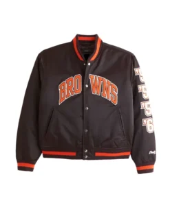 Front of a dark brown Cleveland Browns satin varsity bomber jacket with "BROWNS" across the chest and vertical numbers "50," "55," "64" on the left sleeve.
