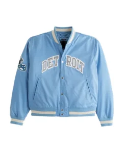 Light blue Detroit Lions varsity bomber jacket with "DETROIT" across the chest and a Lions helmet patch on the left sleeve.