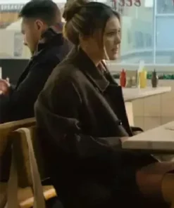 Jingle Bell Heist Olivia Holt Brown Long Coat. Sophia (Olivia Holt) wearing the long brown coat and her hair up, sitting in a diner scene from the movie.