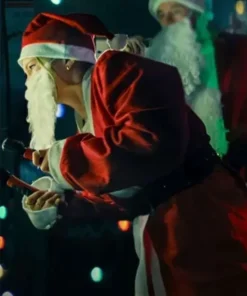 A woman in a red Santa costume leans forward while holding an object in a festive, low-lit setting.