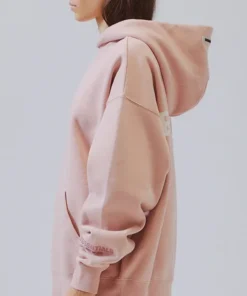Side profile of the Essentials peach hoodie from Pacsun, showing the sleeve detail and hood. A great loungewear piece.