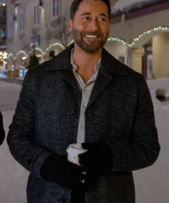 Man wearing a dark black wool coat with a wide collar, standing outdoors in a snowy street at night.