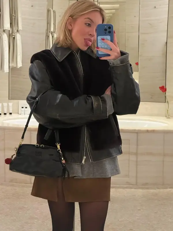 Sydney Sweeney in a black leather with shearling blouson jacket and brown skirt; the perfect black sherpa leather jacket for a winter outfit.