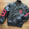 A sleek 8 Ball Bomber Jacket Black featuring vibrant red leather sleeves and bold circular graphics.