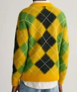 Back view of a yellow fuzzy sweater with green and black argyle pattern.