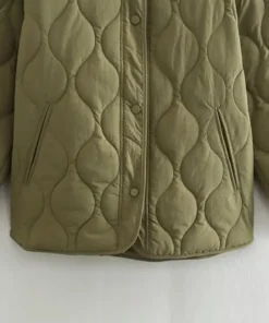 Detail of a Womens Quilted Green Jacket showing the snap fasteners and deep side pockets on a lightweight olive green quilted jacket for women.