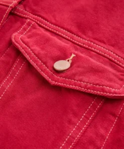 Close-up of a buttoned chest pocket on a red jeans jacket, showing durable stitching and premium fabric of this stylish red denim style jacket.