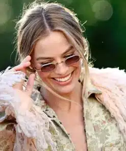 Close-up of Margot Robbie Wuthering Heights London look, featuring tinted sunglasses and the feathered collar of her John Galliano coat.