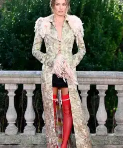 Margot Robbie wears a vintage John Galliano long trim coat at the Wuthering Heights London press photocall, featuring red stockings.